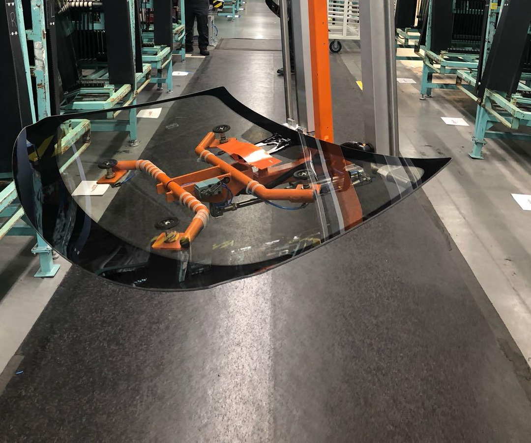 An EFS vacuum frame carrying an automotive windshield through an aisle of glass racks
