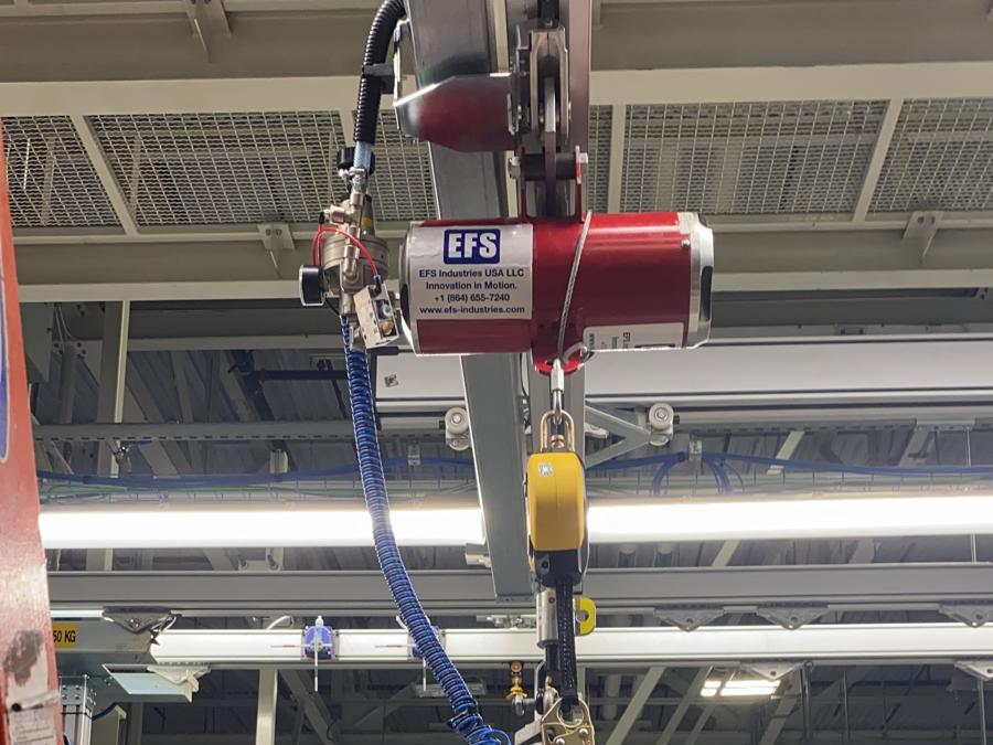 An EFS pneumatic balancer on an overhead rail with a pneumatic gripper below