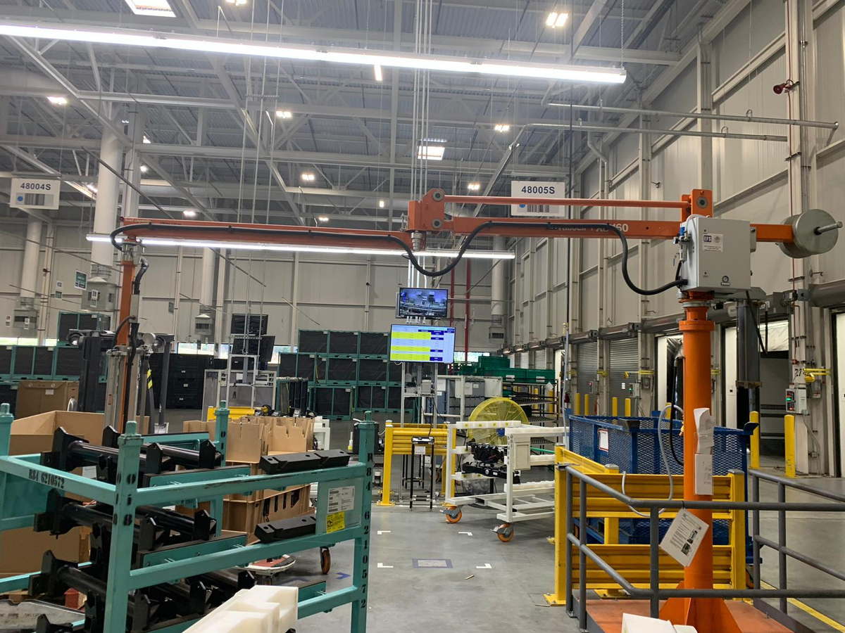 An EFS ratioLIFT jib manipulator at a picking station in a bright production hall
